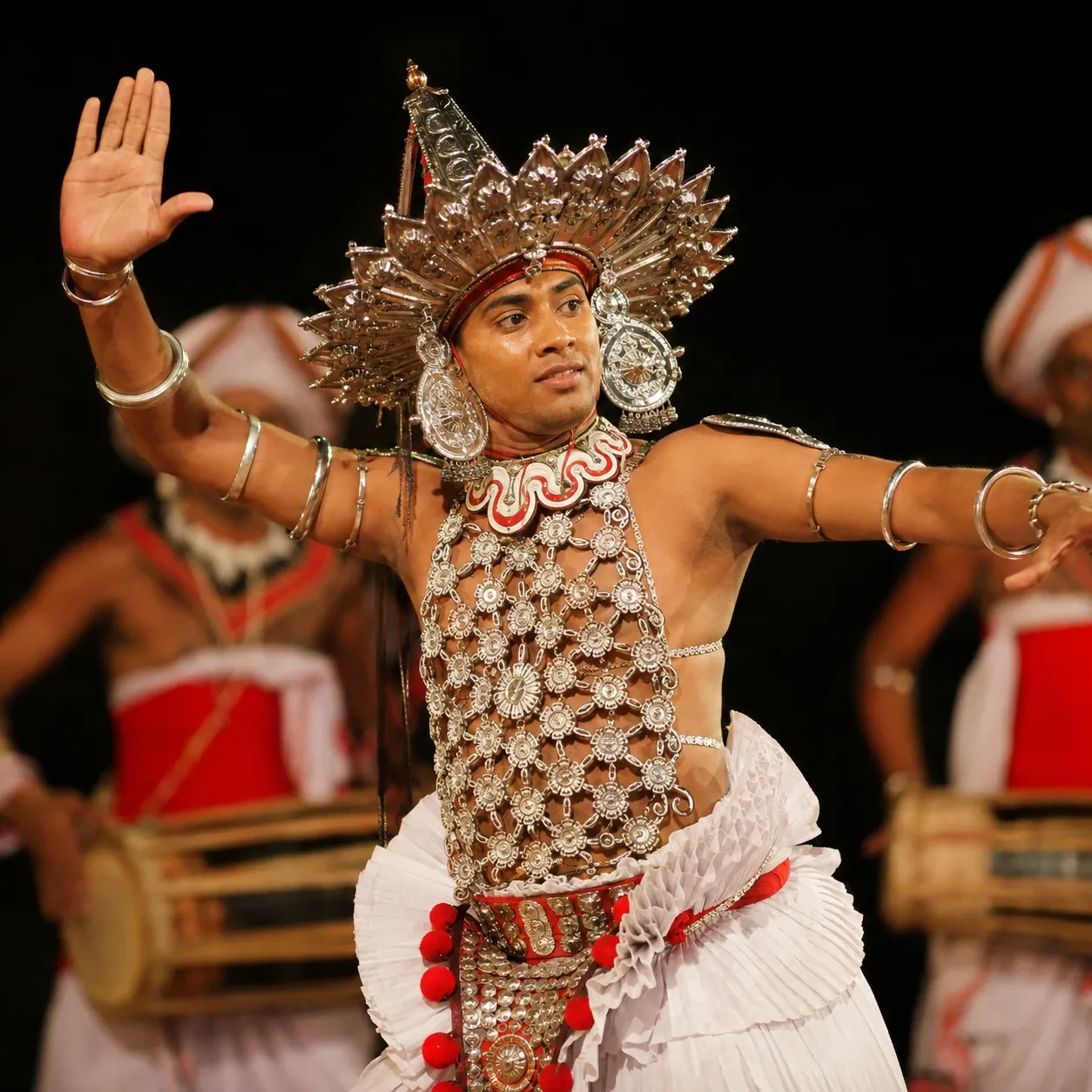 A traditional Kandyan dancer in a silver beaded headdress performing in Kandy, Sri Lanka