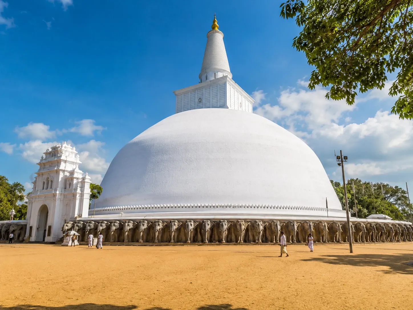 The white Ruwanwelisaya stupa and its elephant wall in the sacred city of Anuradhapura, Sri Lanka