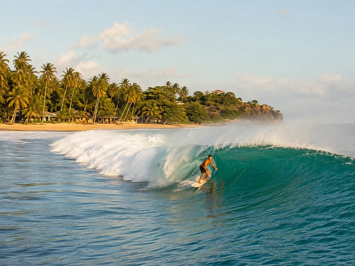 A surfer riding the point break wave at Arugam Bay on the east coast of Sri Lanka